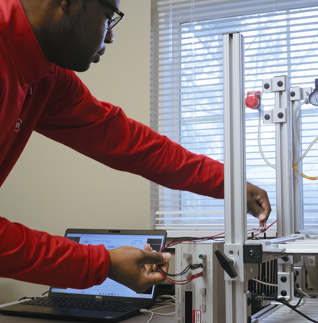 Indesign engineer connecting wiring on an automated test rig