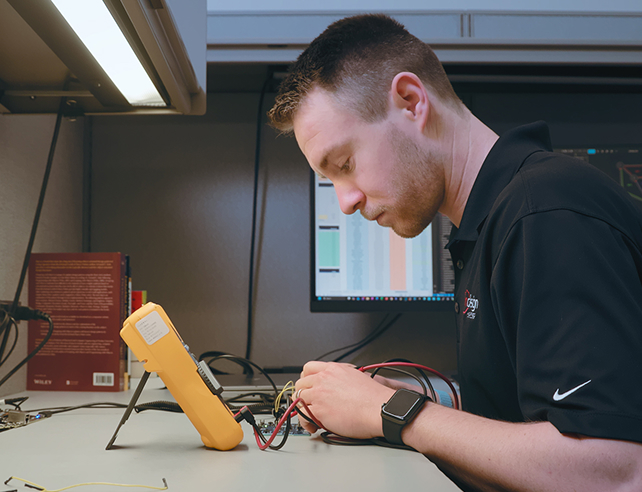Indesign engineer testing a circuit board with a Fluke multimeter