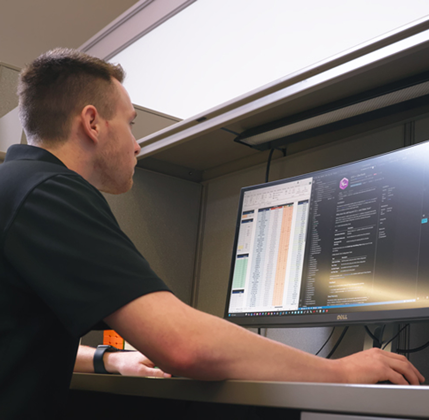 Indesign firmware engineer reviewing code and project data at his workstation