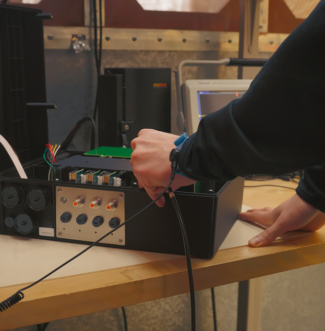 Engineer connecting a circuit board to a test instrument